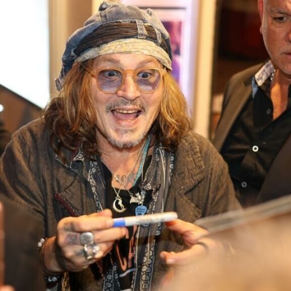 Johnny signeerasi iloisesti fanien tavaroita. Johnny Depp