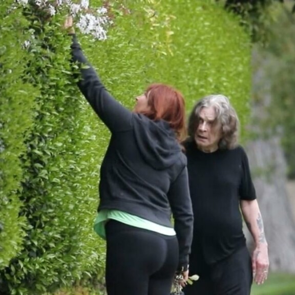 Ozzyn avustaja poimi kukkia lenkkireitin viereisestä pensaasta. Ozzy Osbourne