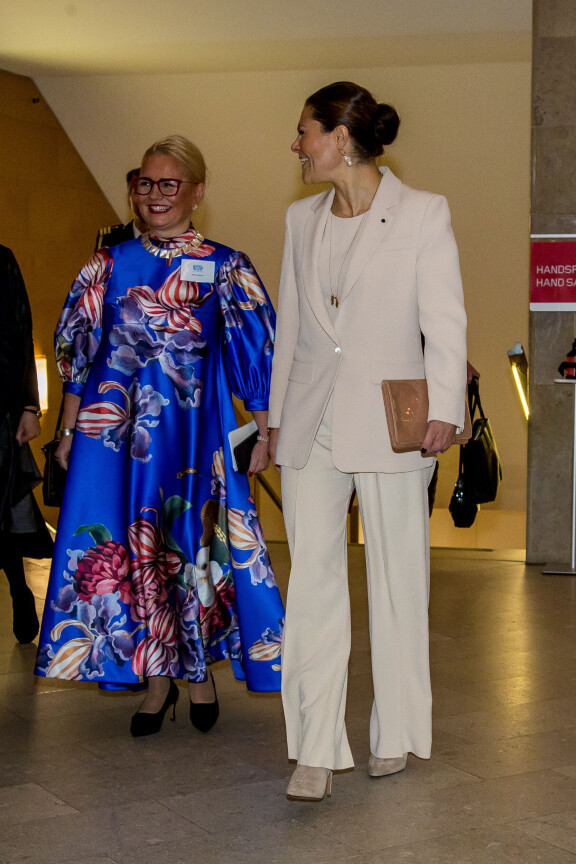 Jakkupuvun lahkeiden alta pilkistivät asuun sopivat piikkikorkokengät.