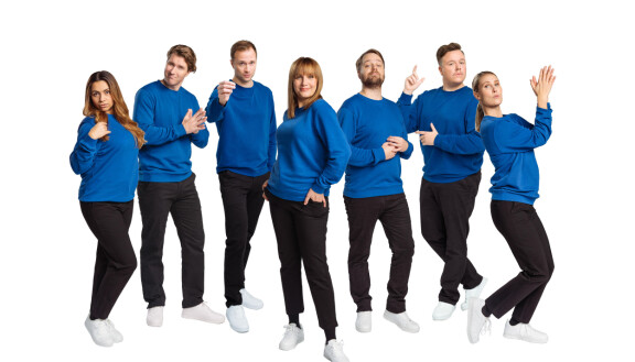 Kuuden näyttelijän tukena kameroiden edessä on juontaja Niina Lahtinen.