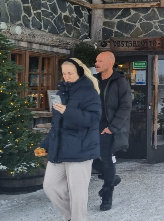 Nanna kantoi eväitä käsissään ja selaili luuria, kun Jere seurasi kannoilla.