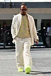 Helteisessä Abu Dhabissa viime vuoden lopulla Lewis Hamilton keikaroi teddynallepuvussa ja neonkeltaista sekä kukkakuosia yhdistävässä neulepaidassa. Vaaleanpunainen kännykkäkuori ja neonkeltaiset tai melkein -vihreät kengät täydentävät asun sekä todella poikkeukselliset värit harmonialla.