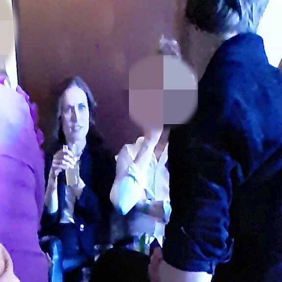 Sanna kumosi drinksuja tiukka ilme kasvoillaan. Oikealla puolella on mies, jolle pääministeri antoi hieronnan. Sanna kumosi drinksuja tiukka ilme kasvoillaan. Oikealla puolella on mies, jolle pääministeri antoi hieronnan.
