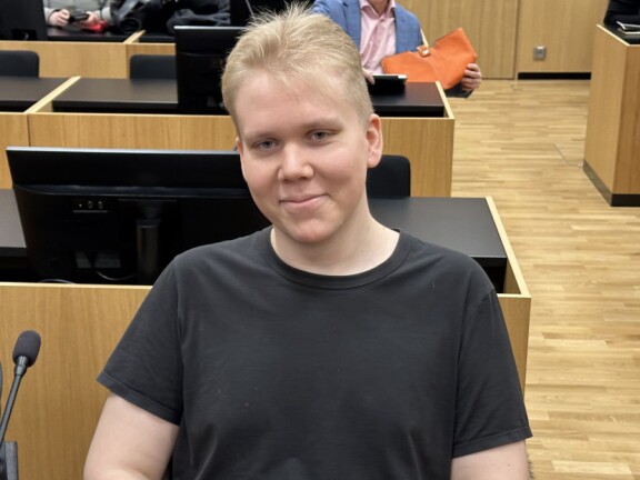 Aleksanteri Julius Kivimäki hymyili kuvaajalle oikeudessa.