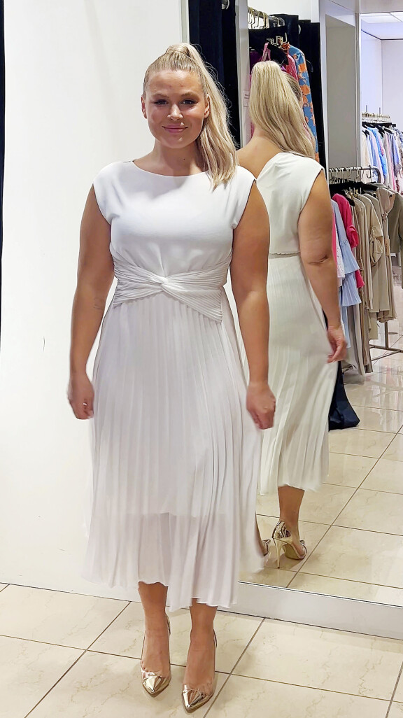 Valkoisen mekon
yläosa, keskivartalon yksityiskohta ja kauniisti
laskeutuva helma tekivät siitä
elegantin.
