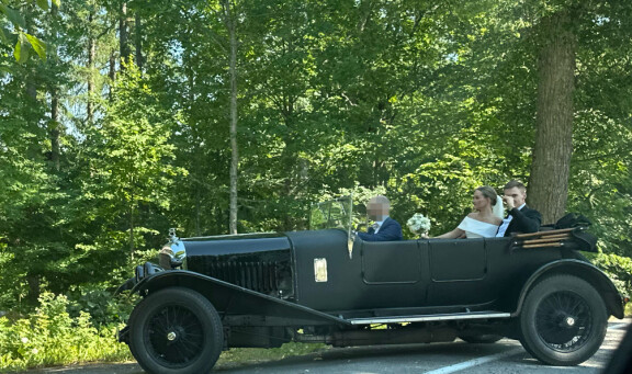 Nelli Matula ja Elias Kaskinen odottivat hetken aikaa juhlapaikan ulkopuolella auton kyydissä, kun hääkuvaaja avasi portin seurueelle.
