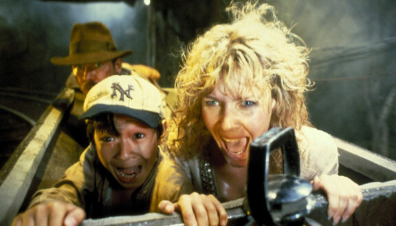 Indiana Jones (taka-alalla), Short Round (Ke Huy Quan) ja Willie Scott (Kate Capshaw) kaivosvaunun kyydissä.