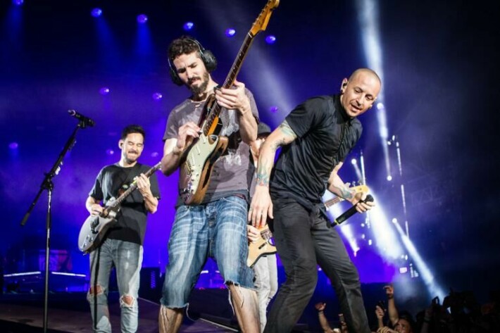 Linkin Parkin nokkamies Chester Bennington (oik.) menehtyi vuonna 2017. Vasemmalla Mike Shinoda ja keskellä Brad Derson  - luurit päässä, kuinkas muuten.