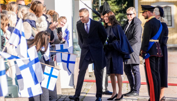 Vieraita tervehdittiin Suomen lippujen heilutuksella.