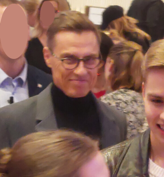Hymyilevä isä ja hänen edessään hymyilevä poika juttelivat ystäviensä kanssa, ja isä vastaili ohikulkijoiden ystävällisiin, sanattomiin tervehdyksiin.