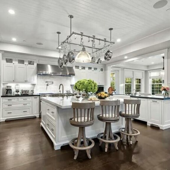 Modernia keittiötä hallitsevat tumma puu ja valkoinen värimaailma. Keskellä tilavaa huonetta on iso saareke. Modernia keittiötä hallitsevat tumma puu ja valkoinen värimaailma. Keskellä tilavaa huonetta on iso saareke.