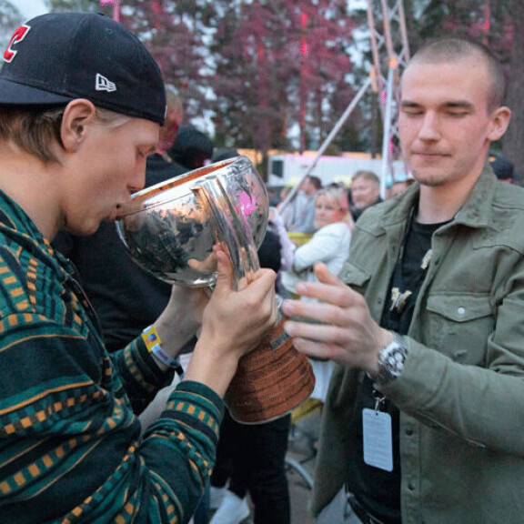 Laaksonen ja Vainionpää hörppivät alkoholia kannusta vuorovedoin. Laaksonen ja Vainionpää hörppivät alkoholia pystistä vuorovedoin.