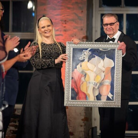 Missikeisarin viitan perinyt Sunneva Kantola ojensi Einolle Miss Suomi 2019 -finaalissa Johanna Oraksen maalaamaan Kruunajaiset-taulun. Missikeisarin viitan perinyt Sunneva Kantola ojensi Einolle Miss Suomi 2019 -finaalissa Johanna Oraksen maalaamaan Kruunajaiset-taulun.
