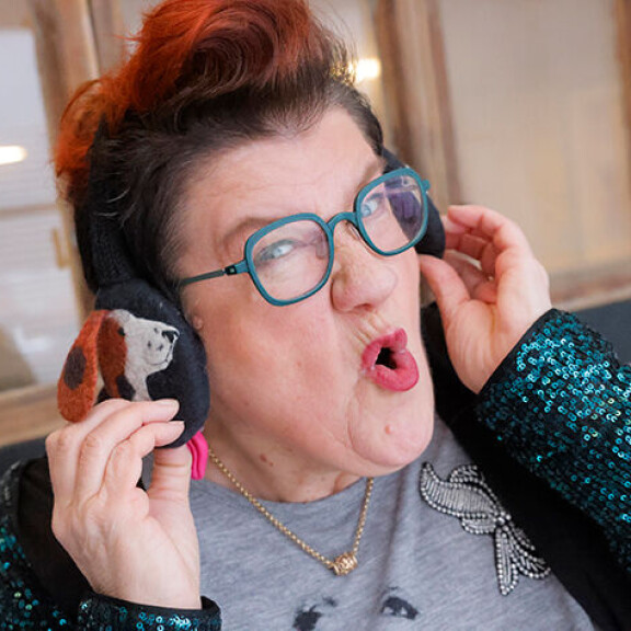 Korvaläpät kuuluvat Anittan kiroilevan rollaattorimummon asuun. Anitta Ahonen