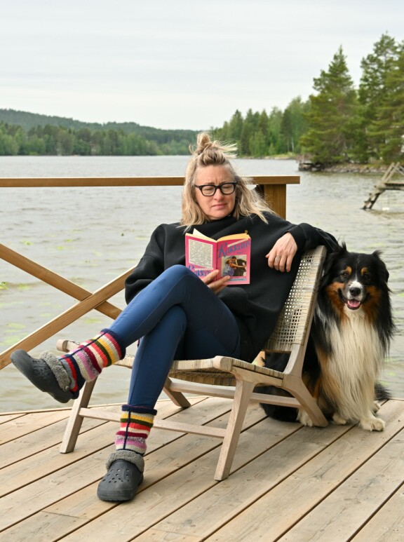 Pieni vaaleanpunainen kirja seuraa Katjaa kaikkialle, mihin tahansa hän mökillään meneekin.