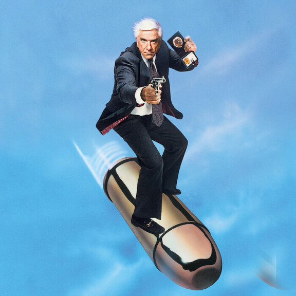 Mies ja alaston ase oli jatkoa suositulle tv-sarjalle Hei me pamputetaan. Molemmissa yleisöä nauratti Leslie Nielsen.