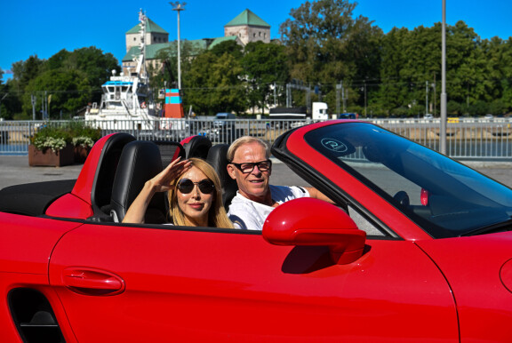 Sukarit liikenteessä: tulenpunainen Porsche kiiltää kilpaa auringon kanssa. – Elämästä pitää nauttia!