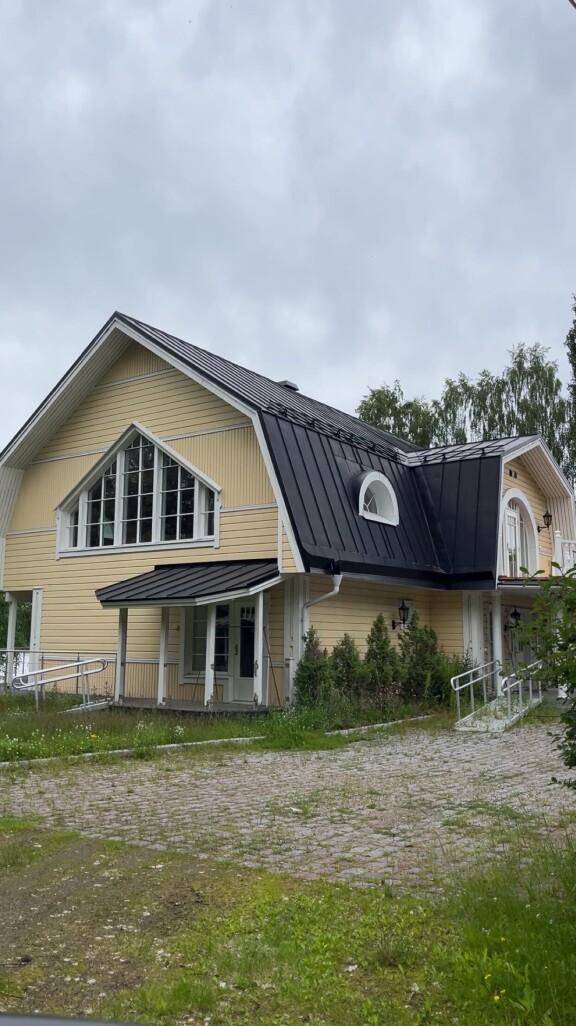 Osa parvekkeen (oik.) kaiteesta on pudonnut ja komeista pylväistä lohkeilee maali. Rikkaruohot ovat vallanneet pihatien.
