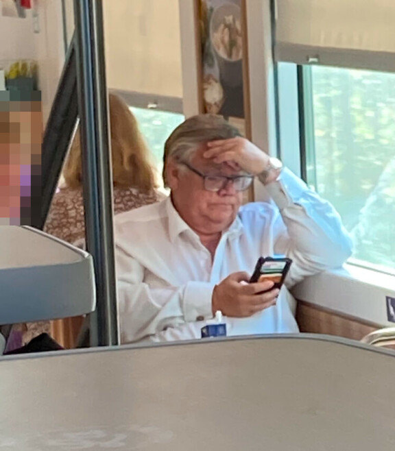 Timo katseli keskittyneenä kännykkäänsä ruokailun aikana.