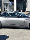 Kuva Cheekistä eli Jare Tiihosesta istumassa Aston Martinissa eli urheiluautossa pelkääjän paikalla