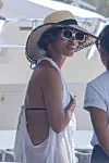 Halle Berry hymyili jahdin kannella valkoisessa läpikuultavassa rantatunikassa, jonka alta vilahtivat tummat bikinit. Olkihattu ja valkoiset aurinkolasit viimeistelivät lomailijan tyylin.