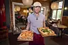 Tuukka Temonen pizzeria Rehtorissa pizzat kädessään.
