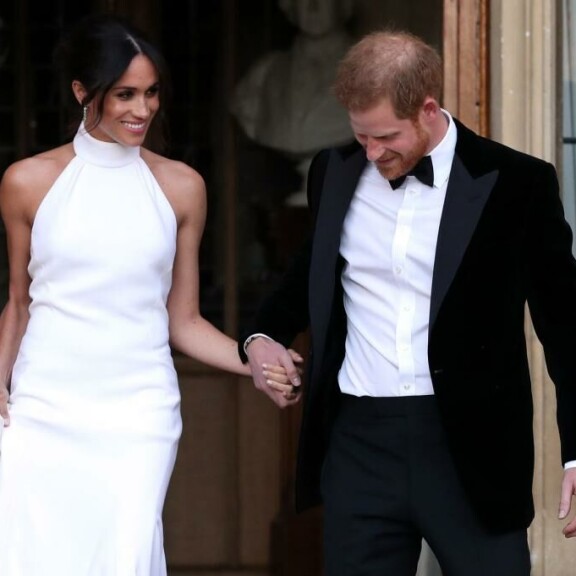 Meghan vaihtoi vihkitilaisuuden jälkeen asunsa hovin etikettisääntöjä rikkovaan, olkapäät paljastavaan asuun. MEGHAN, HARRY