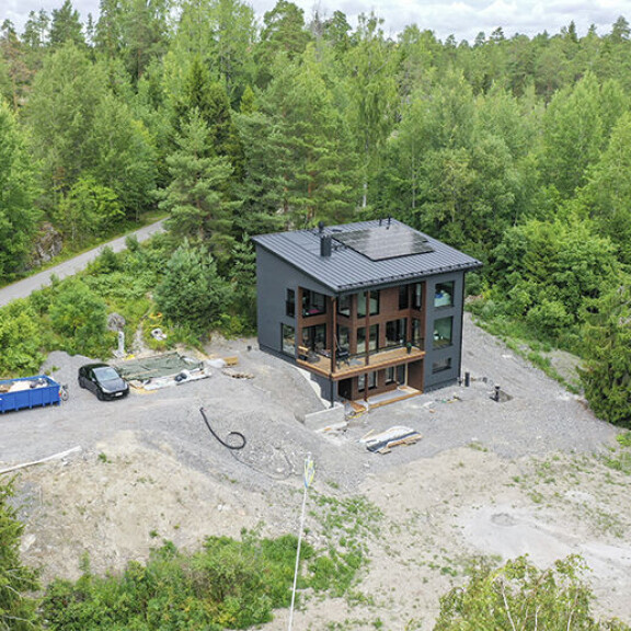 Kastellin kolmikerroksinen moderni talo hallitsee rinnetonttia ylväänä. Joel ja Janni talo