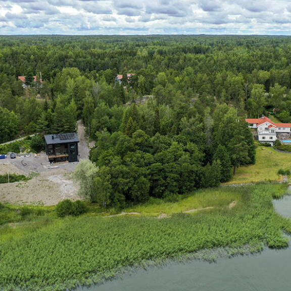 Uuden talon iso koko on häivytetty nätisti tontille ja sitä ympäröivään metsään. joel ja janni talo