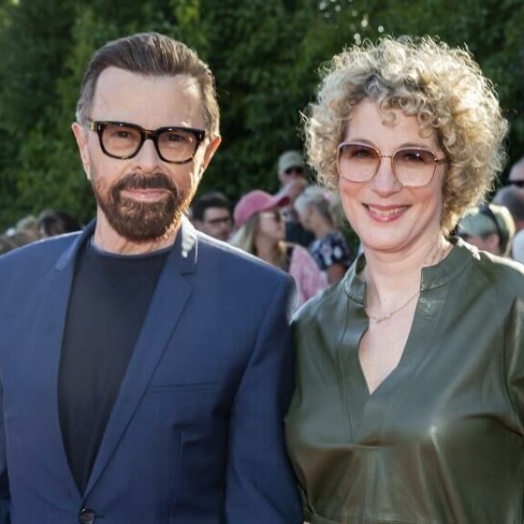 Björn edusti punaisella matolla maireana uuden kultansa Christinan kanssa. Björn Ulvaeus, Christina Sas