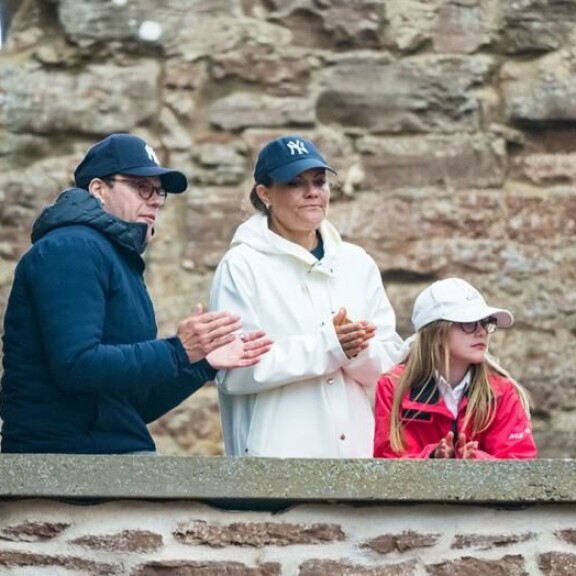 Victoria vaikutti viluiselta sadetakissaan. Ruotsin kruununprinsessapari Victoria ja Daniel sekä prinsessa Estelle