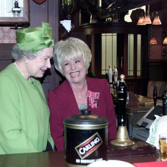 EastEndersin näyttelijä Barbara Windsor esitteli kuningattarelle sarjan kulisseja syksyllä 2001. Dame Barbara kuoli joulukuussa 2020. Kuningatar Elisabet ja Barbara Windsor