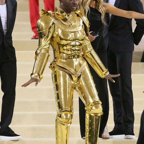 Vaikka julkkikset eivät saa rouskuttaa sipulia illallisella, näyttäviin asuihin sonnustautuminen on enemmän kuin suotavaa. Tässä räppäri Lil Nas X kultapuvussaan viime vuoden gaalassa. Asu on Versacen käsialaa, ja koostuu kolmesta eri kerroksesta. Lil Nas X