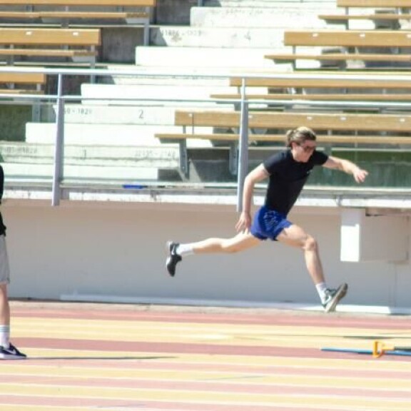 Personal trainer seurasi silmä kovana nuorukaisen pituushyppyharjoituksia. Personal trainer seurasi silmä kovana nuorukaisen pituushyppyharjoituksia.