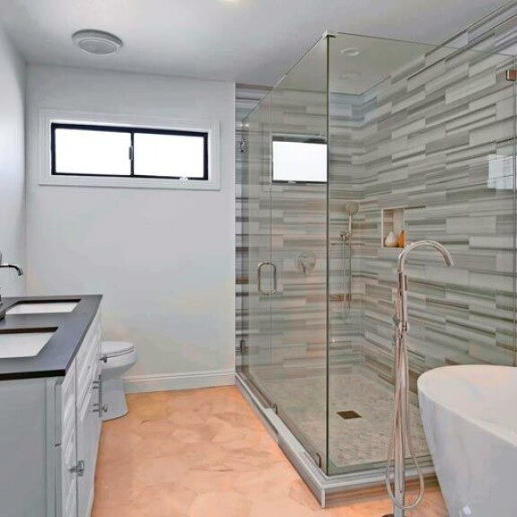 Kylpyhuoneen kaakeloinnissakin näkyy moderni koskestus. Suihkutilat ovat harmaata kiveä. Kylpyhuoneen kaakeloinnissakin näkyy moderni koskestus. Suihkutilat ovat harmaata kiveä.