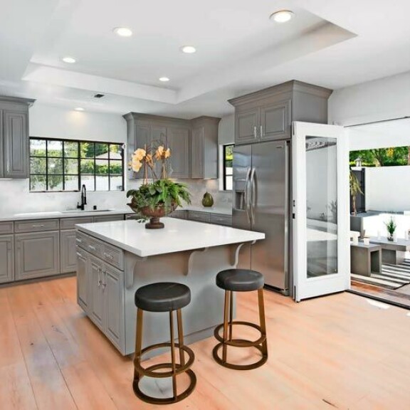 Harmaa sävy vallitsee myös keittiösaarekkeessa ja kaappien ovissa. Pariovista aukeaa näkymä takapihalle. Harmaa sävy vallitsee myös keittiösaarekkeessa ja kaappien ovissa. Pariovista aukeaa näkymä takapihalle.