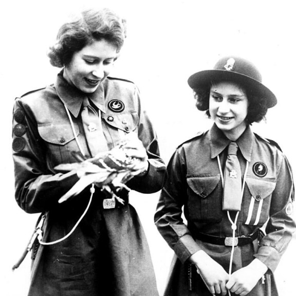 Vuonna 1943 napatussa kuvassa silloinen prinsessa Elisabet ja siskonsa prinsessa Margaret lähettivät kirjekyyhkyn matkaan. Siskokset olivat mukana partiotoiminnassa. kuningatar elisabet, prinsessa margaret