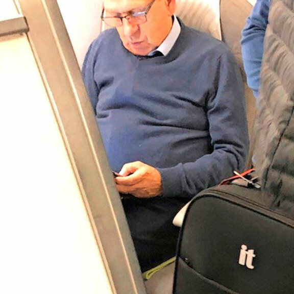 Konkaripoliitikko Erkki Liikanen tutkaili älylaitettaan lentokoneessa – kuva! Erkki Liikanen lentokoneessa.
