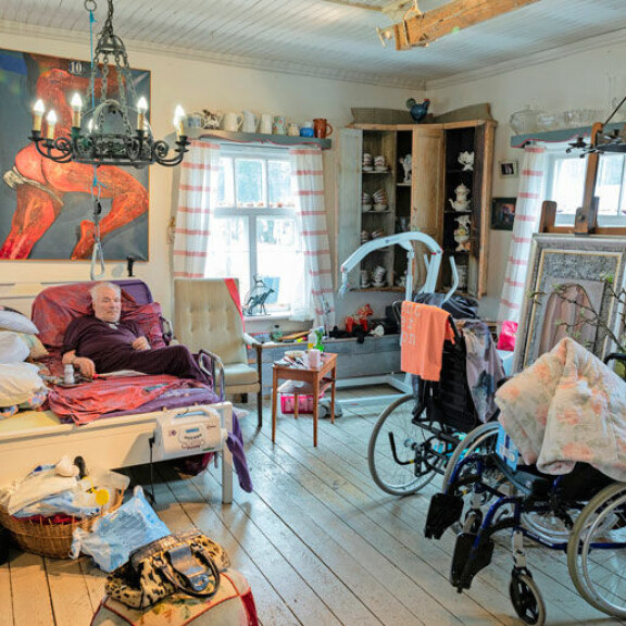 Juhani ei pysty liikkumaan omin voimin. Leilan avuksi taloon on hankittu nostin (oikealla ylälaidassa), jolla hän saa nostettua Juhanin sängystä selkäänsä rasittamatta. Juhani ei pysty liikkumaan omin voimin. Leilan avuksi taloon on hankittu nostin (oikealla ylälaidassa), jolla hän saa nostettua Juhanin sängystä selkäänsä rasittamatta.