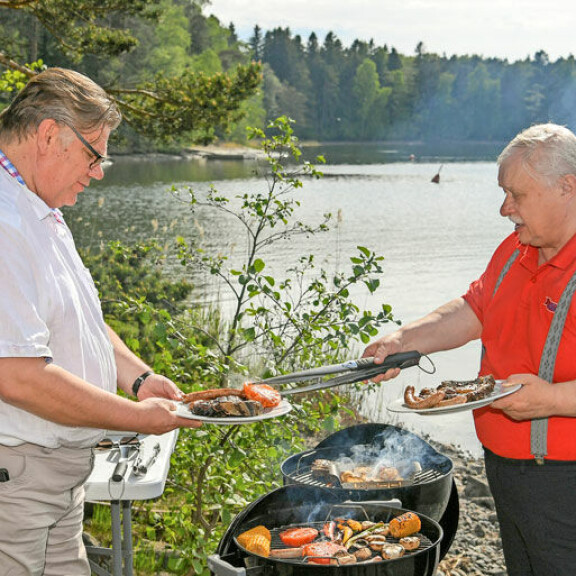 Veijo annostelee grillatut eväät ulkoministerille tottunein ottein. Veijo annostelee grillatut eväät ulkoministerille tottunein ottein.