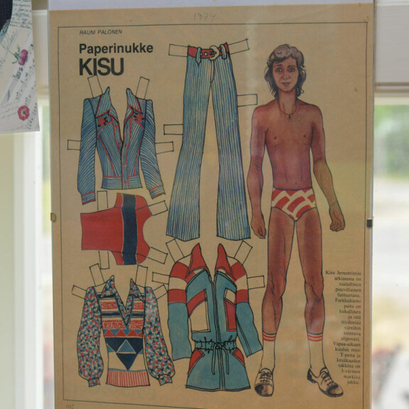 Kyläkaupan seinällä on paljon muistoja vuosien varrelta. Kuvassa Kisu-paperinukke vuodelta 1972. Kyläkaupan seinällä on paljon muistoja vuosien varrelta. Kuvassa Kisu-paperinukke vuodelta 1972.