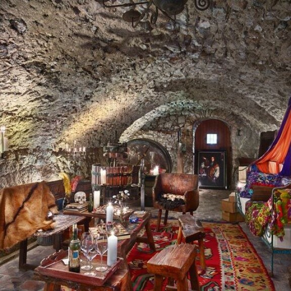 Värikkäästi sisustettu makuuhuone henkii luolamaista tunnelmaa upeine kiviseinineen. Värikkäästi sisustettu makuuhuone henkii luolamaista tunnelmaa upeine kiviseinineen.